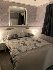 a bedroom with a bed with a mirror on the wall at Bluebell lodge in Fort William