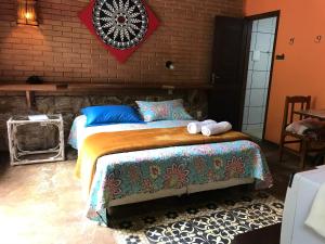 1 dormitorio con 1 cama grande y toallas. en Reserva dos Manacás en São Pedro da Serra