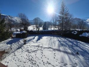 a snow covered yard with the sun in the background at Chalet 8-10 personnes Auris en Oisans Domaine de l'Alpe d'Huez in Auris