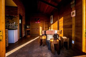 una habitación con mesa y taburetes en una cabaña en Chalés Belo Vale - Ibitipoca, en Conceição da Ibitipoca