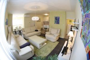 ein Wohnzimmer mit weißen Sofas und einem Tisch in der Unterkunft Apartment Zubčić in Zadar