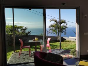 a room with a view of the ocean through a glass door at Casa Atlantico tropischer Seitenflügel in Ribeira Brava