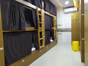 a row of bunk beds in a room with windows at Super SleepWell Male-Female Hostel in Mumbai