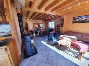 Chalet 8-10 personnes Auris en Oisans Domaine de l'Alpe d'Huez في أوري: غرفة معيشة مع موقد خشب في كابينة