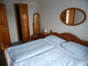 1 dormitorio con cama y espejo en Ferienwohnungen Engelmühle en Nordstrand