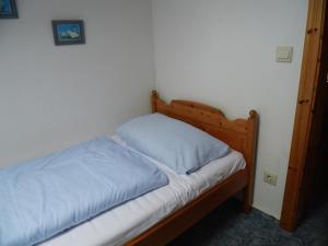 Bett mit einem Kopfteil aus Holz in einem Schlafzimmer in der Unterkunft Ferienwohnungen Engelmühle in Nordstrand
