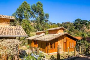une petite maison en bois à côté d'une maison dans l'établissement Chalés Belo Vale - Rua do Curro, à Conceição da Ibitipoca