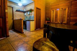 a kitchen with a counter and a refrigerator at Chalés Belo Vale - Rua do Curro in Conceição da Ibitipoca