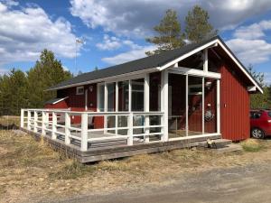 a red and white building with a red at Hailuoto Marjaniemi - Rantasumppu Cottage 2 - With Sauna - Close to the beach in Hailuoto
