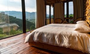 a bedroom with a bed and a large window at Eco Hotel Glamping El Silencio in Santa Rosa de Cabal