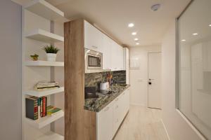 a kitchen with white cabinets and a counter top at Apartamentos Marqués de Abastos in Logroño