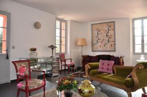 uma sala de estar com um sofá verde e cadeiras em Villa Chandra em Biot