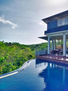 a house with a swimming pool next to a house at Bagus Ink Surf Camp in Uluwatu