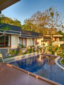 an external view of a house with a swimming pool at Bagus Ink Surf Camp in Uluwatu