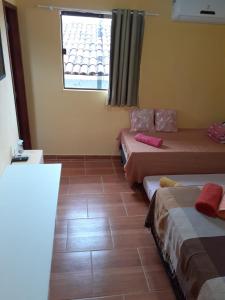 um quarto com duas camas e uma janela em Recanto Novo Horizonte no Recife