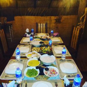 a table with plates of food on it at Hasthi Safari Cottage in Udawalawe
