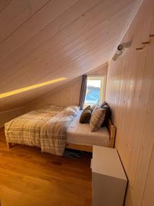 a small bed in a room with a window at Skarvebo - cabin with amazing view in Myro