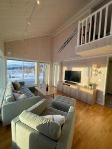 ein Wohnzimmer mit 2 Sofas und einem TV in der Unterkunft Skarvebo - cabin with amazing view in Myro
