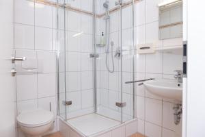 a bathroom with a shower and a toilet and a sink at Gasthaus Hotel Kranz in Laufenburg