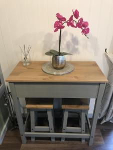 a table with a vase with purple flowers on it at Wyncliffe Hideaway in St. Davids