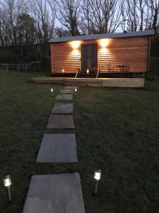 a small log cabin with lights on the grass at Wyncliffe Hideaway in St. Davids