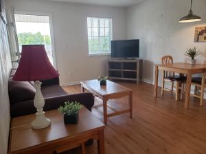 una sala de estar con sofá y una lámpara en una mesa. en Affordable Suites Burlington, en Burlington