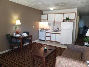 ein Wohnzimmer mit einem Tisch und einer Küche in der Unterkunft Affordable Suites Burlington in Burlington