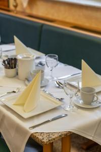 a table with white plates and napkins on it at Hotel Esmer in Lollar
