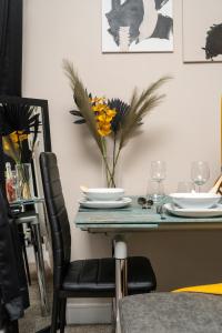 a dining room table with a vase of flowers on it at JPG Tower Suite - 22nd Floor Canal & City Views in Manchester