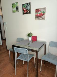 a dining room table with chairs and paintings on the wall at Przytulne mieszkanie blisko Galerii Bałtyckiej Zaspa in Gdańsk +1 photo
