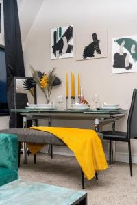 a dining room table with a yellow blanket on it at JPG Tower Suite - 22nd Floor Canal & City Views in Manchester