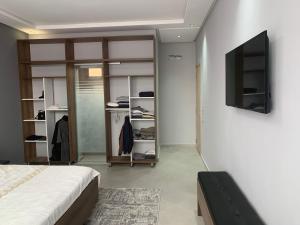 a bedroom with a bed and a tv on a wall at Riad L'Aéroport in Marrakesh +34 photos