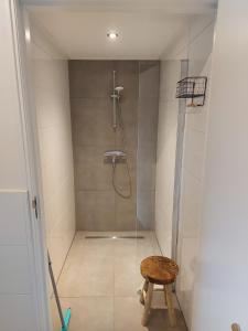 a bathroom with a shower with a wooden stool at Camping het Smitske in Drunen