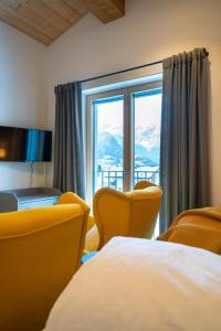a hotel room with a bed and a large window at Naturhaus Netzer in Schruns-Tschagguns +19 photos