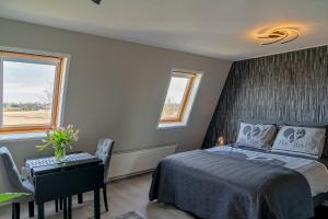 a bedroom with a bed and a table and a window at Liv Inn Hillegom in Hillegom