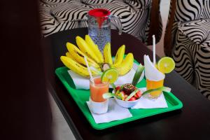 a tray with fruit and drinks on a table at Royal Park Hotel in Jinja