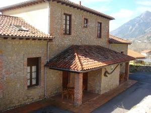 an outside view of a house with a roof at Apartamentos Rurales La Escuela in Buelles