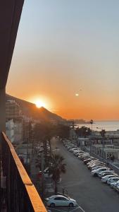 una puesta de sol sobre un aparcamiento con coches aparcados en Beautiful Apartment on The First Line of The Sea, en Haifa