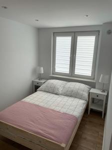 1 Schlafzimmer mit einem großen Bett und 2 Fenstern in der Unterkunft Apartament -Dwudziestka in Sandomierz