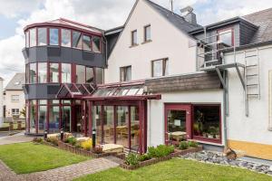 an exterior view of a house with glass windows at Landhotel Wolf-Mertes in Sessenbach