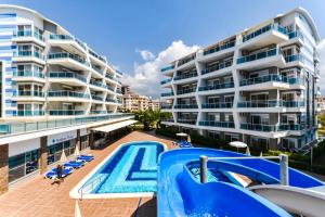 an apartment with a swimming pool and a building at SA Apartments! Crystal Family Suites in Alanya
