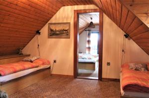 a attic room with two beds and a mirror at Vila Líška in Pavčina Lehota