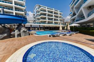 a swimming pool next to a large apartment building at SA Apartments! Crystal Family Suites in Alanya