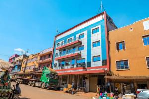 er staat een vrachtwagen voor een gebouw geparkeerd bij Royal Park Hotel in Jinja