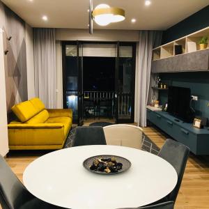 ein Wohnzimmer mit einem weißen Tisch und einer gelben Couch in der Unterkunft Royal Suite in Avezzano
