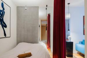 a bedroom with a bed and a red curtain at Etern Stays - Boutique Apartment in Pristina +3 photos