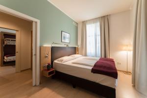 a bedroom with a large bed and a window at Hotel Stiegl Scala in Bolzano