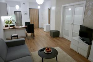 uma sala de estar com um sofá e uma mesa em Kieślowskiego Apartment vis-a-vis Town Hall em Varsóvia