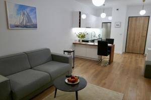 uma sala de estar com um sofá, uma mesa e uma cozinha em Kieślowskiego Apartment vis-a-vis Town Hall em Varsóvia