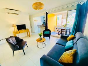a living room with a blue couch and chairs at Hamo Cosy in Sainte-Anne +40 photos